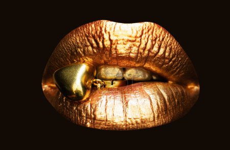 Téléchargez les photos : Femmes lèvres dorées, fermer le fond isolé. Bouche isolée en or. Concept de bijoux - en image libre de droit