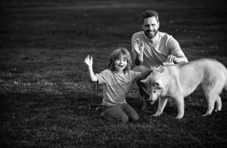 Foto de Feliz padre e hijo con perro en el parque. Actividad de fin de semana feliz concepto de estilo de vida familiar - Imagen libre de derechos