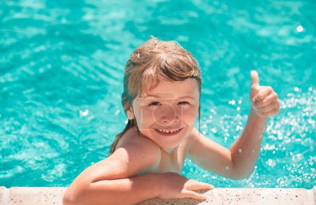Photo for Kid boy swim in swimming pool with thumbs up. Happy little kid boy playing with in outdoor swimming pool on hot summer day. Kids learn to swim. Family beach vacation - Royalty Free Image