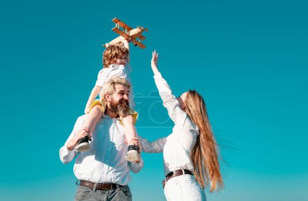 Photo for Children day. Happy family mother, father and child with toy plane. Child dreaming future, dreams and travels. Young parents and their child are very happy, freedom to dream - Royalty Free Image