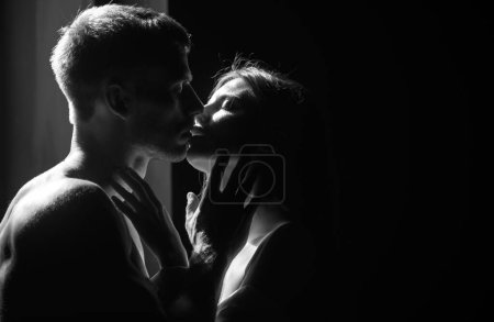 Foto de Un beso apasionado. Cerca de la cara de retrato sensual de una sexy pareja abrazando mientras citas. Pareja joven enamorada de negro. El encantador coupl pasa tiempo juntos - Imagen libre de derechos