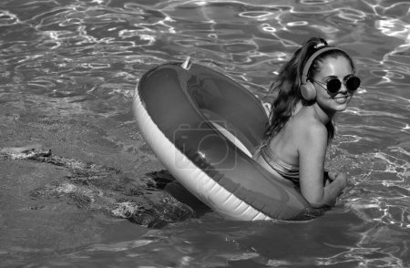 Foto de Mujer joven de verano. Disfrutando del bronceado. Mujer en traje de baño en círculo inflable en la piscina - Imagen libre de derechos