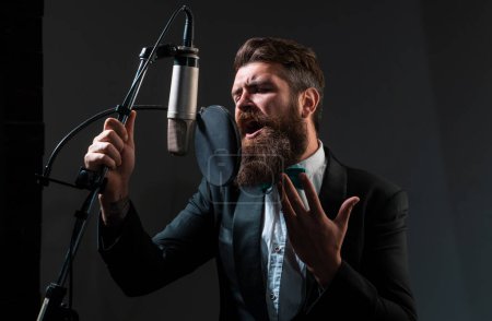 Téléchargez les photos : Homme avec microphone chantant dans le music hall - en image libre de droit