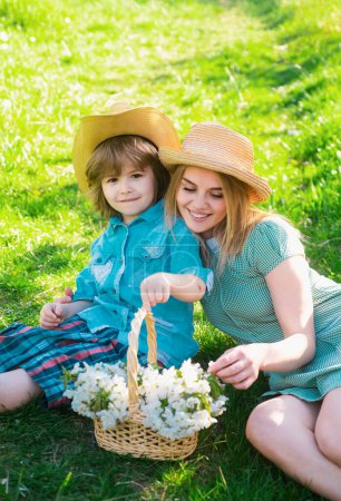 Téléchargez les photos : Famille de jardiniers joyeux assis lors d'un pique-nique dans le jardin. Jeune famille souriante se détendre au soleil jour. - en image libre de droit