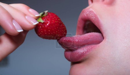 Téléchargez les photos : Léchage de fraise. Sucer la fraise avec la langue. Bouche sensuelle. Femme sensualité de la langue léchant fraise. Sensuelle bouche féminine sexy avec la langue qui sort. Macro fraise Lick - en image libre de droit