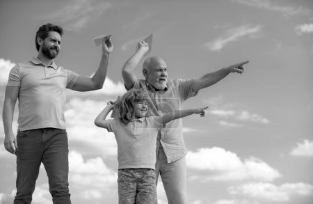 Foto de Tres generaciones diferentes edades abuelo padre e hijo hijo jugando con avión de juguete al aire libre. Viaje viaje viaje concepto de viaje - Imagen libre de derechos
