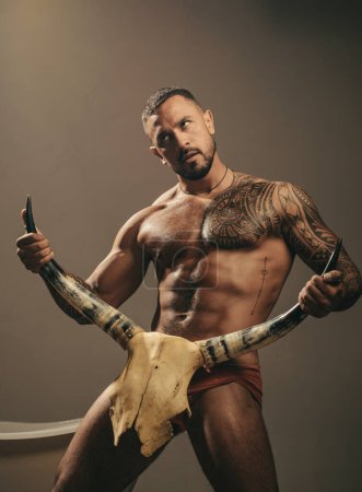 Téléchargez les photos : Homme sexy avec érotique masculin, corps six pack tenir cornes de taureau - en image libre de droit