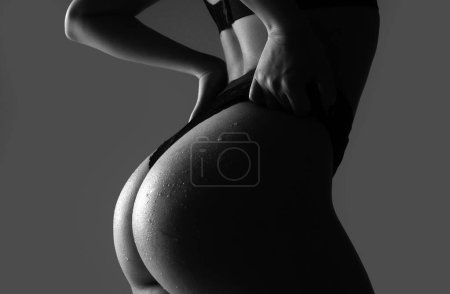 Foto de Sexy ass buttocks slim figure, bikini thong underwear. Woman sexy silhouette body in panties. Putting panties off, undress - Imagen libre de derechos