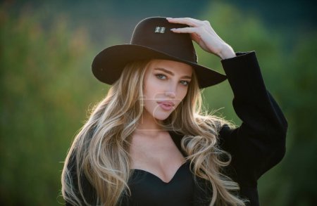 Foto de Sensual retrato de mujer joven y elegante en amplio sombrero de ala ancha al aire libre. Hermosa chica de moda - Imagen libre de derechos