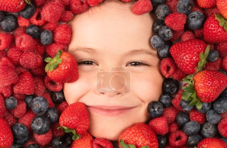 Téléchargez les photos : Fruits d'été. Enfants visage avec des baies mélange de fraise, myrtille, framboise, mûre - en image libre de droit