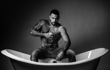 Foto de Sexy hombre con cuerpo desnudo lavado en la bañera - Imagen libre de derechos