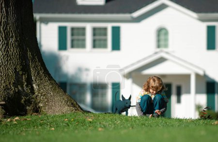 Foto de Seguro de niños. Niño con perro paseando al aire libre. Cachorros y niños jugando en el parque. Familia, paternidad, concepto de infancia - Imagen libre de derechos
