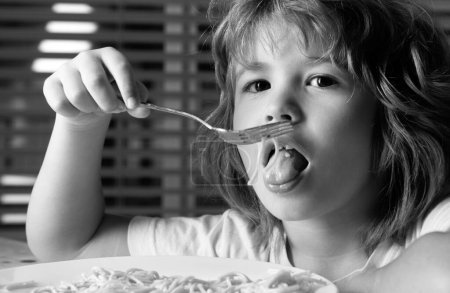 Photo for Close up portrait of a cute little child eating pasta, spaghetti. Childhood concept - Royalty Free Image