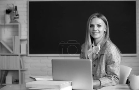 Téléchargez les photos : Étudiante ciblée, jeune femme en ligne regardant le webinaire sur ordinateur portable, écoutant le cours de formation à l'apprentissage, assis au bureau de travail en classe, concept d'apprentissage en ligne. Webinaire en ligne, enseignement à distance par appels vidéo - en image libre de droit