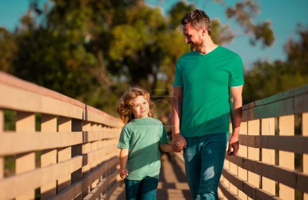 Téléchargez les photos : Heureux père et petit garçon fils marchant dans le parc d'été. Père élever son fils - en image libre de droit