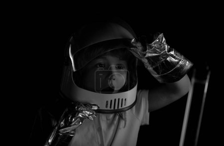Photo for Close-up face of little astronaut with helmet looking dreamily. Isolated background with copy space. Close up excited kids face on neon color - Royalty Free Image