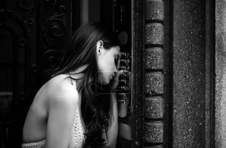 Foto de Lady mujer timbre de intercomunicación en la entrada del edificio. Vestido joven femenino ingresando código en el teclado de la puerta - Imagen libre de derechos
