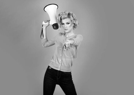 Photo for Megaphone and women. Portrait of pinup girl shouting. Young excited blonde fun woman pointing finger to the front. Idea for marketing or sales banner - Royalty Free Image