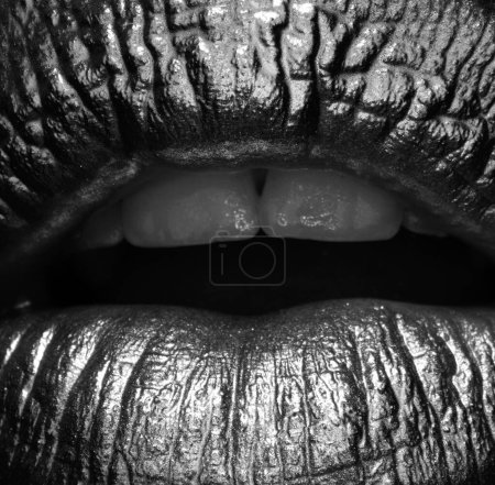 Foto de Macro cierra los labios dorados. Pintura dorada de la boca. Labios dorados en boca de mujer con maquillaje. Diseño sensual y creativo para metal dorado - Imagen libre de derechos