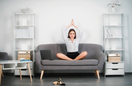 Meditation bei der Arbeit. Ruhige junge Geschäftsfrau macht Pause bei Yoga-Übungen am Arbeitsplatz, glückliche Sekretärin meditiert am Schreibtisch zu Hause