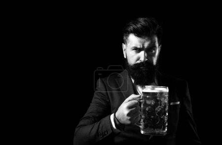 Foto de Retrato de hombre hipster barbudo serio sostiene cerveza artesanal isoalted en negro - Imagen libre de derechos