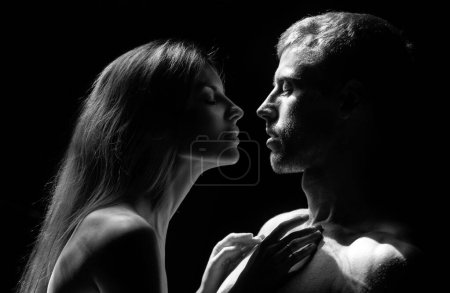 Foto de Hombre abrazando y va a besar a la mujer sensual. Pareja cariñosa besándose sobre fondo negro. Amor verdadero en el día de San Valentín - Imagen libre de derechos