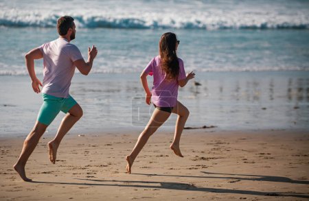 Foto de Deportista y deportista corriendo juntos por el mar. Pareja corriendo en la playa - Imagen libre de derechos