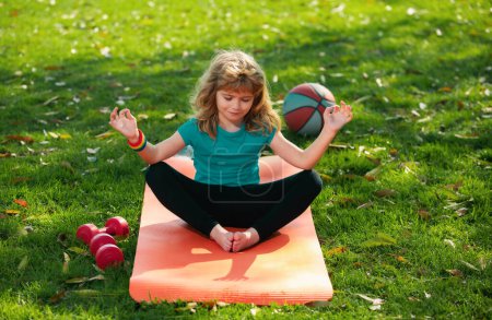 Photo for Child doing exercise outdoors. Healthy kids lifestyle. Yoga children in park doing yoga asana. Lifestyle relaxation concept, summer outdoor harmony with nature - Royalty Free Image