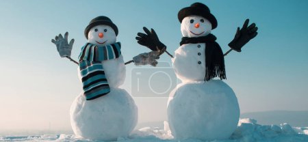 Téléchargez les photos : Des bonhommes de neige tenant la main dehors. Bonhomme de neige d'hiver en bonnet noir, écharpe et gants. Bannière d'hiver de Noël avec bonhomme de neige. Carte de voeux d'hiver avec bonhomme de neige - en image libre de droit