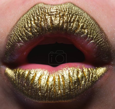 Photo for Close up female plump lips with gold. Golden glitter lipstick. Shine style for sexy lip. Sensual woman lips. Luxury golden mouth. Glamour gold lips. Golden lips with golden paint or metallic lipstick - Royalty Free Image