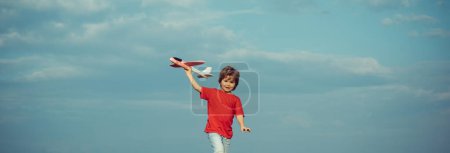 Foto de Primavera y niño. Banner para encabezado del sitio web. Niño jugando con juguete avión sobre prado divertirse y sonreír - Imagen libre de derechos