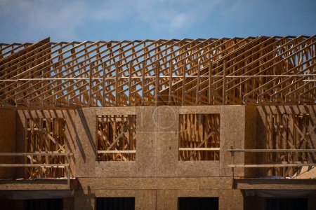Photo for Roof building. Standard timber framed building with roof trusses. Roof Timber Frame house. The frame of the new build home. Construction site. Roof trusses constructed with construction beams timber - Royalty Free Image