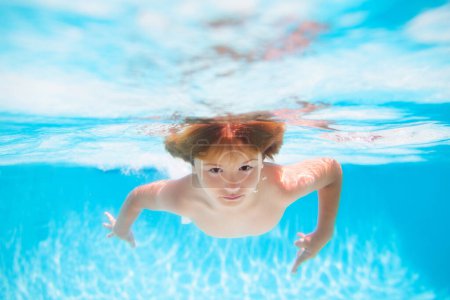 Foto de Kid boy swimming underwater on the beach on sea in summer. Blue ocean water. Child boy swimming in sea - Imagen libre de derechos