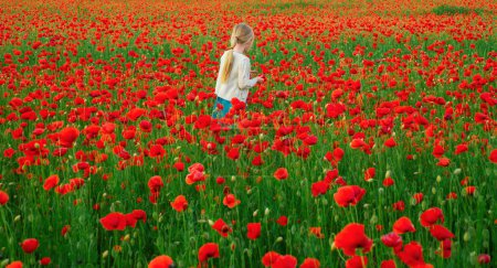 Photo for Little girl on the poppies meadow. Beautiful daughter on a poppy field outdoor. Spring flower blossom meadow background - Royalty Free Image