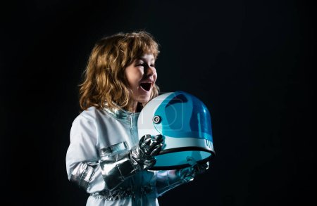 Photo for Little boy wearing an astronaut helmet costume and. Cute kid in astronaut playing and dreaming of becoming a spacemen - Royalty Free Image