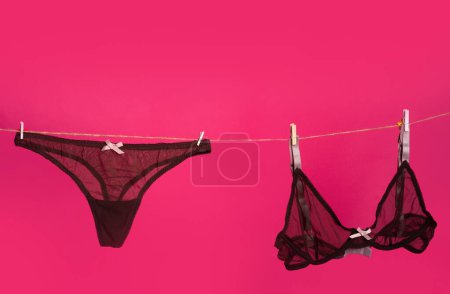 Foto de Bragas de encaje. La lencería sexy aislada en el fondo rojo rosado. Bragas bikini tanga, sujetador negro y lencería de ropa interior - Imagen libre de derechos