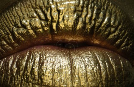 Foto de Macro cerrar los labios dorados sexy, arte de oro. Oro maquillaje brillante en los labios - Imagen libre de derechos
