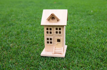 Téléchargez les photos : Maison de jouet en bois sur herbe. Concept immobilier d'assurance - en image libre de droit