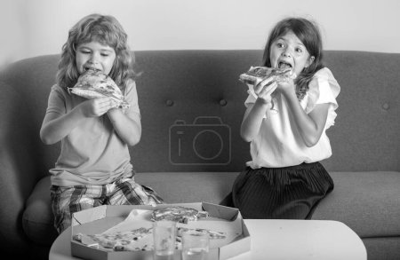 Photo for Funny cute children girl and boy eating tasty pizza. Hungry children eating pizza - Royalty Free Image