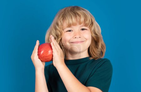 Téléchargez les photos : Pomme rouge. Joyeux sourire enfant fille tenir pomme, santé. Portrait studio - en image libre de droit