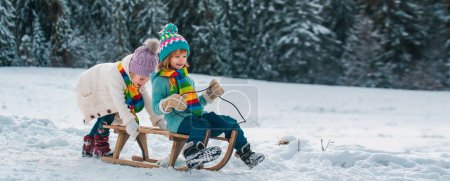 Photo for Boy and girl sledding in a snowy forest. Outdoor winter kids fun for Christmas and New Year. Children enjoying a sleigh ride. Cold and snowy winter mountains - Royalty Free Image