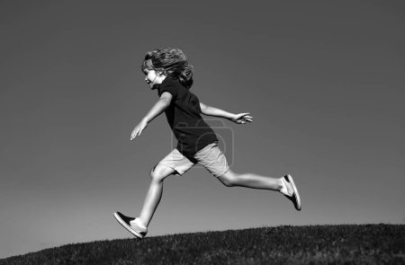 Foto de Chico lindo corriendo sobre hierba. Niños explorando la naturaleza, el verano. Deporte activo y saludable al aire libre. Actividad divertida - Imagen libre de derechos