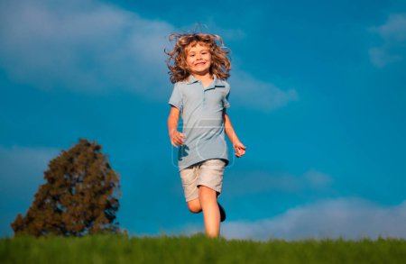 Foto de Niño correr en el parque al aire libre. Un niño de primavera camina sobre hierba. Summer boy. Niños despreocupados - Imagen libre de derechos