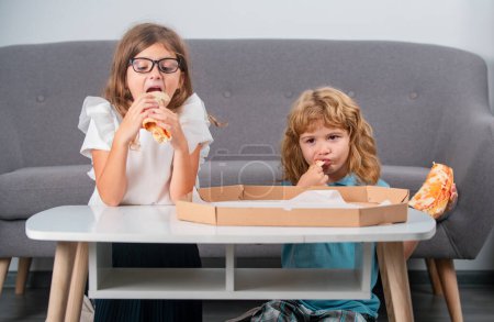 Photo for Hungry kids eating pizza. Funny cute children girl and boy eating tasty pizza - Royalty Free Image