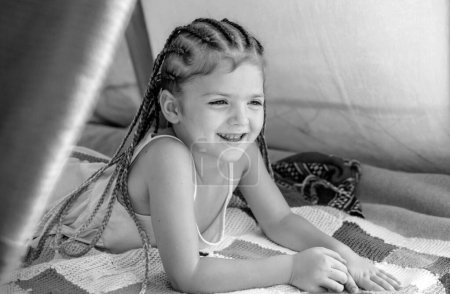 Téléchargez les photos : Concept de campgound pour enfants. Adorable fille jouant dans la tente. Des enfants campent. On s'amuse dehors. Joyeux enfant au camp sur le pique-nique - en image libre de droit