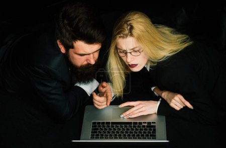 Téléchargez les photos : Couple de jeunes collègues discutant du projet sur un ordinateur portable, équipe d'hommes d'affaires avec ordinateur - en image libre de droit