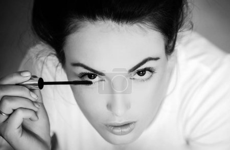 Photo for Beauty portrait of beautiful female model. Beautiful young girl or woman with brown eyes doing makeup with mascara - Royalty Free Image