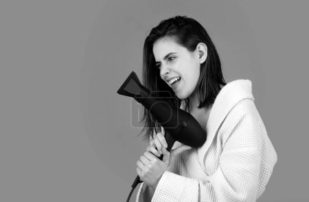 Photo for Young funny woman using fun hair dryer - Royalty Free Image
