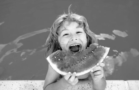 Photo for Child eating watermelon near swimming pool during summer holidays. Kids eat fruit outdoors. Healthy food for children. Little boy playing in pool with a slice of water melon - Royalty Free Image