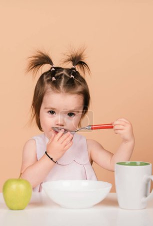 Photo for Kid eat healthy nutrition, baby food. Babies eating with spoon. Kid girl eating healthy food - Royalty Free Image